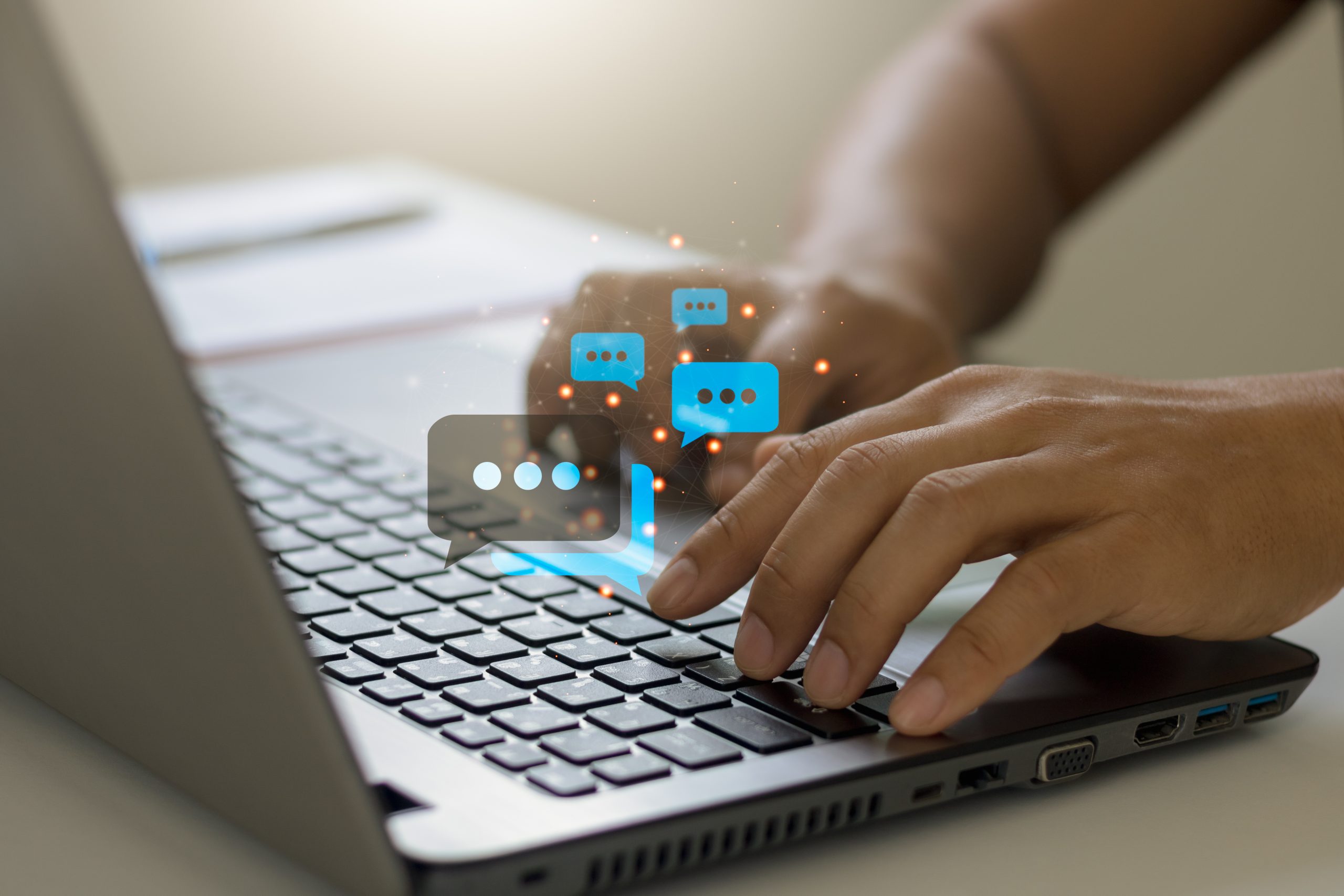 Online live chat chatting on application communication digital media website and social network concept, Close-up hands typing on keyboard laptop computer with chat box icons.